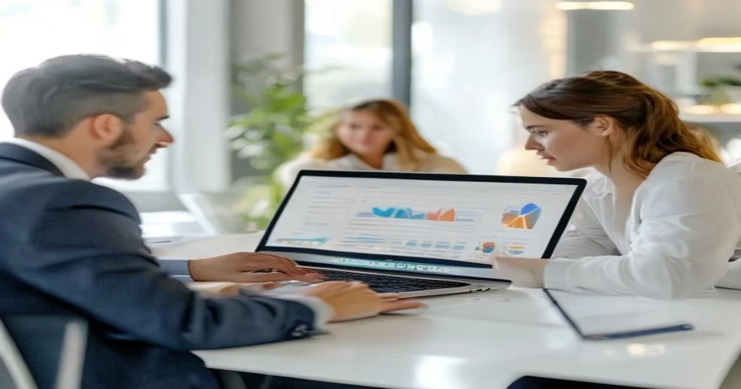 Equipo empresarial gestionando redes sociales desde una laptop en una oficina moderna con iluminación suave
